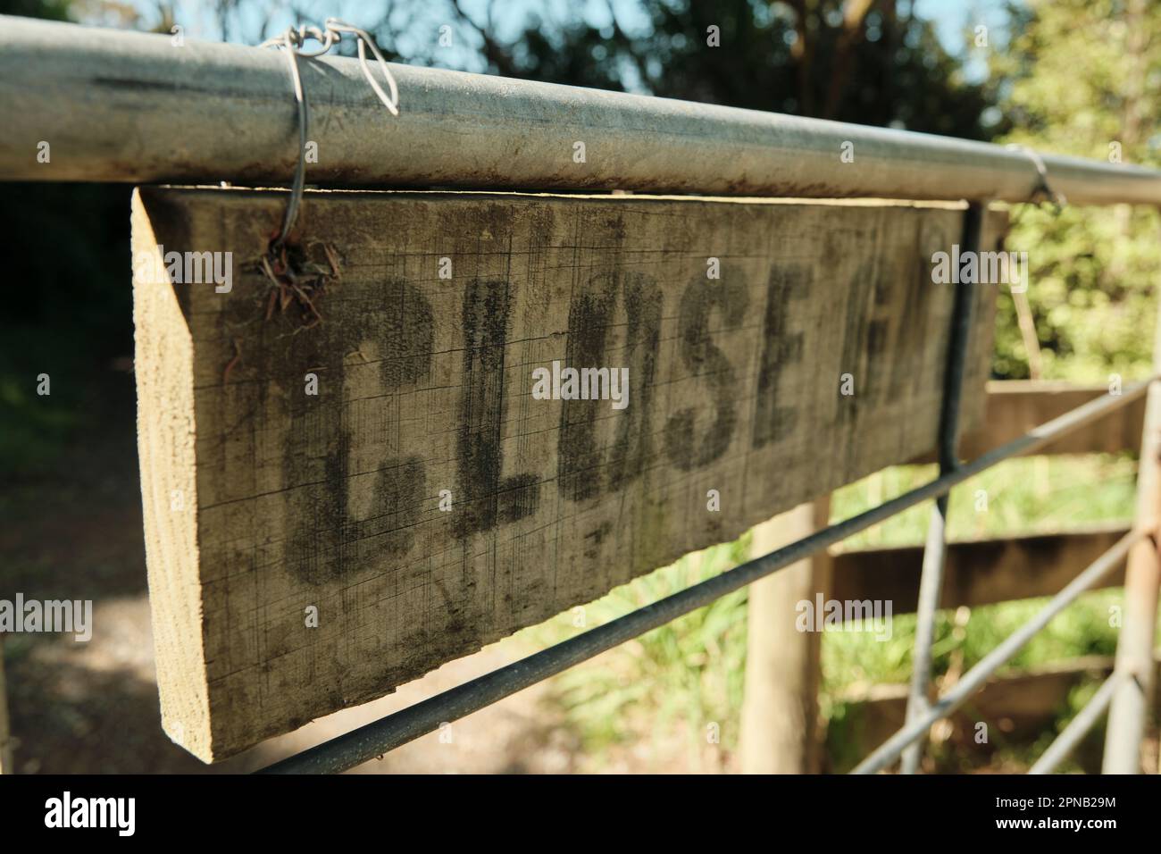 Rustikales Holzschild, das an einem Bauerntor befestigt ist Stockfoto
