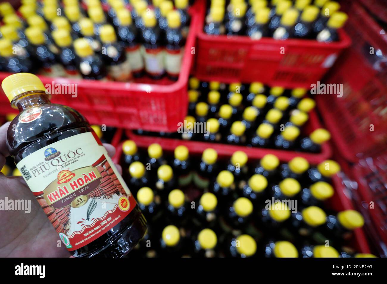 Glasflaschen mit gelbem Plastikdeckel und traditioneller vietnamesischer Fischsauce Nuoc Mam. Phu Quoc. Vietnam. Stockfoto