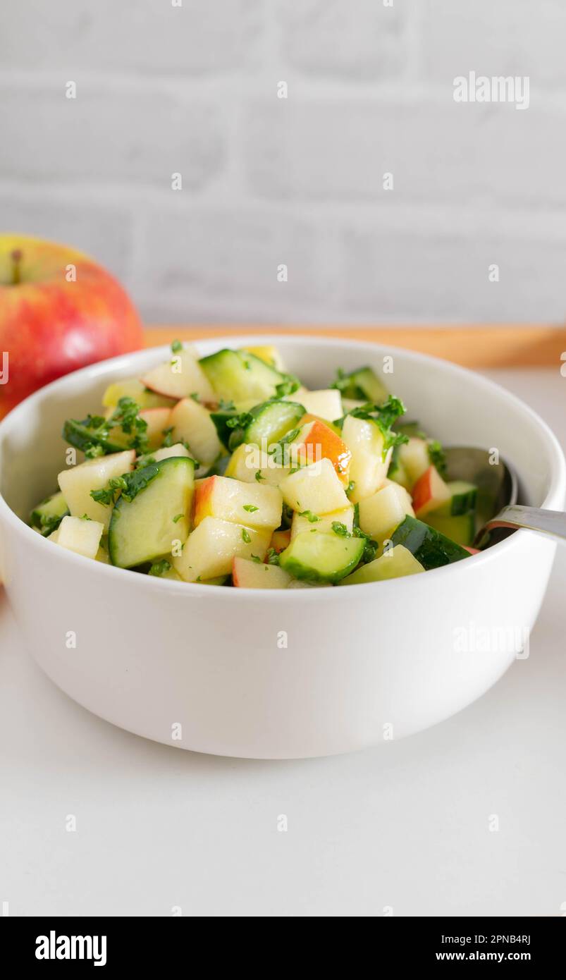 Roher Obst- und Gemüsesalat mit Gurke und Äpfeln mariniert mit Honig, Zitronensaft, Olivenöl und Petersilie Stockfoto