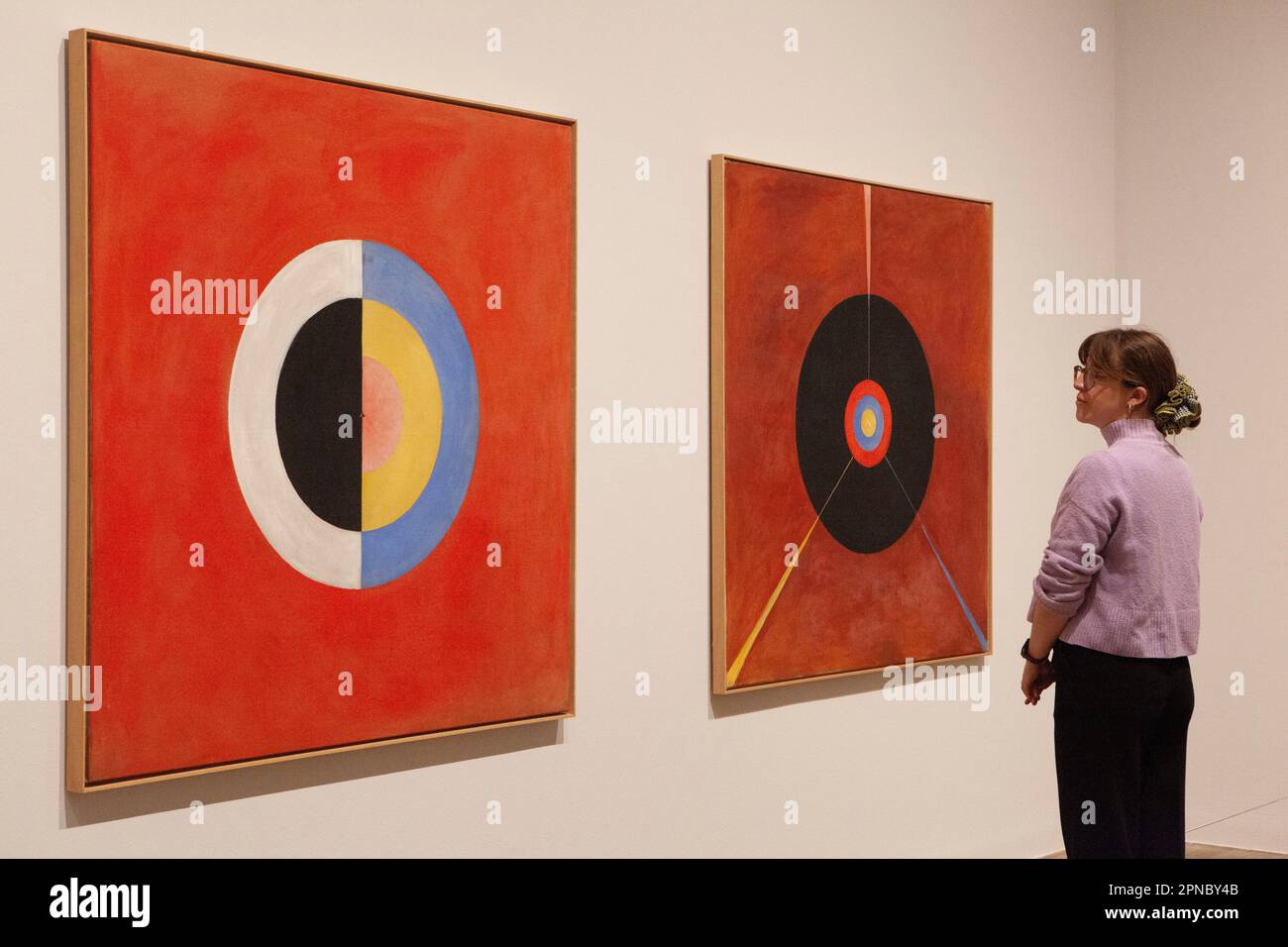 London, Großbritannien. 18. April 2023. Tate Modern präsentiert eine Ausstellung von Hilma af Klint und Piet Mondrian, zwei Pionieren der abstrakten Kunst mit sehr unterschiedlichen Empfindlichkeiten. Eine Frau schaut sich zwei Gemälde von Hilma af Klints 1915 Werken an: „The Swan, the SUW/UW Group IX: Part 1“. Kredit: Anna Watson/Alamy Live News Stockfoto