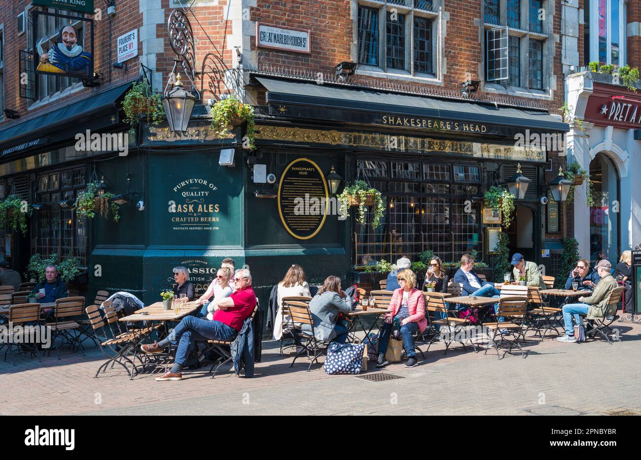 An einem sonnigen Tag entspannen sich die Gäste und genießen Getränke vor dem Shakespeares Head Pub. Great Marlborough Street, Carnaby, London, England, Großbritannien Stockfoto