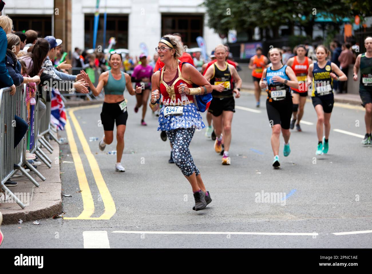 Hanna Thorpe (GBR), vorbei am Cabot Square, verkleidet als Wonder Women, während des London Marathon 2022 Stockfoto