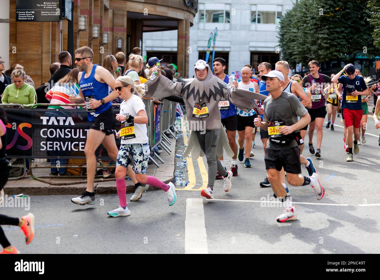 Mark Dean (GBR), der sich wie ein Vogel kleidet, fährt beim London Marathon 2022 über den Cabot Square Stockfoto