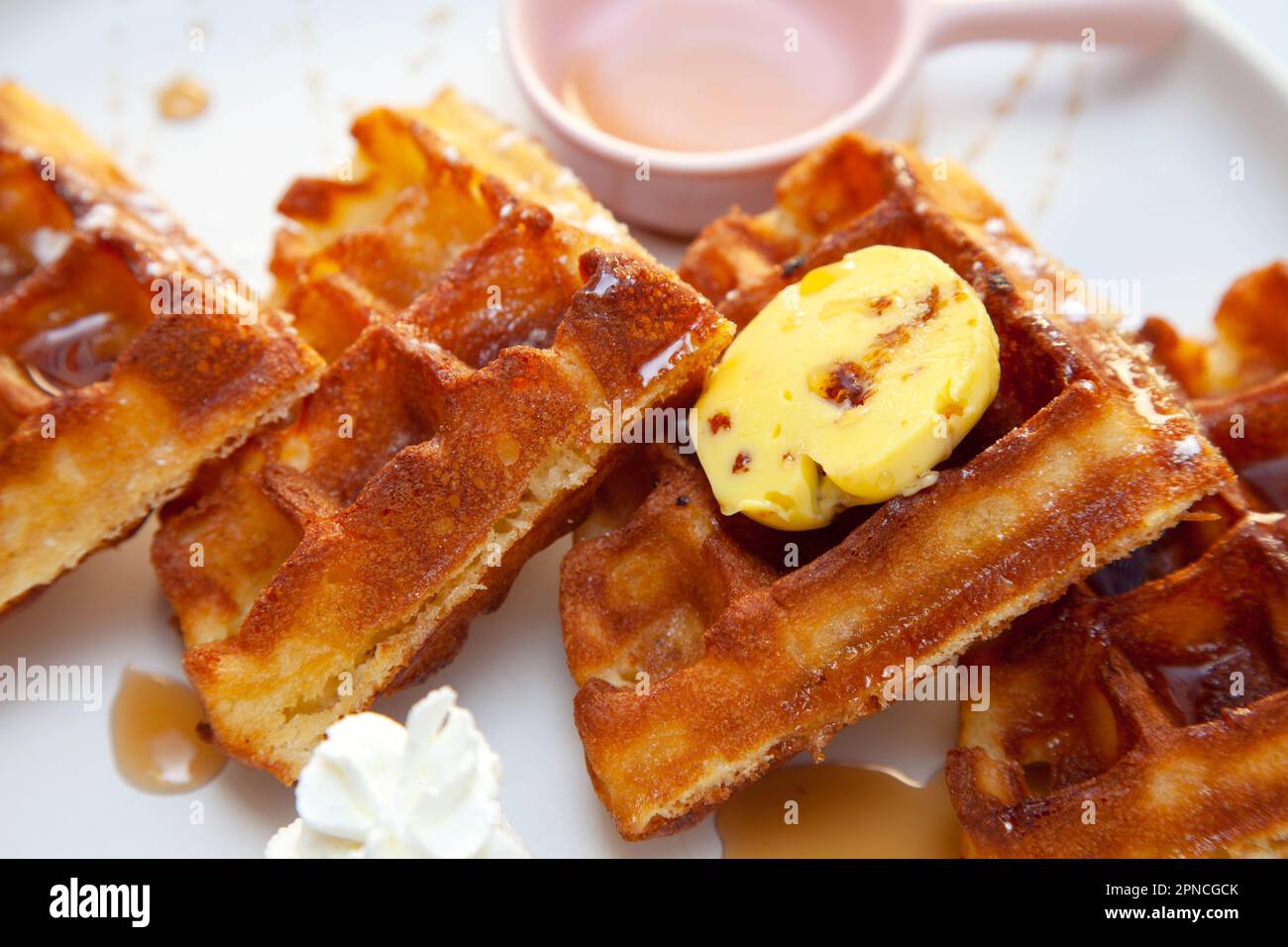 Schokoladenwaffel mit Dressing aus Schokoladensoße und Erdbeereis an der Seite. Stockfoto
