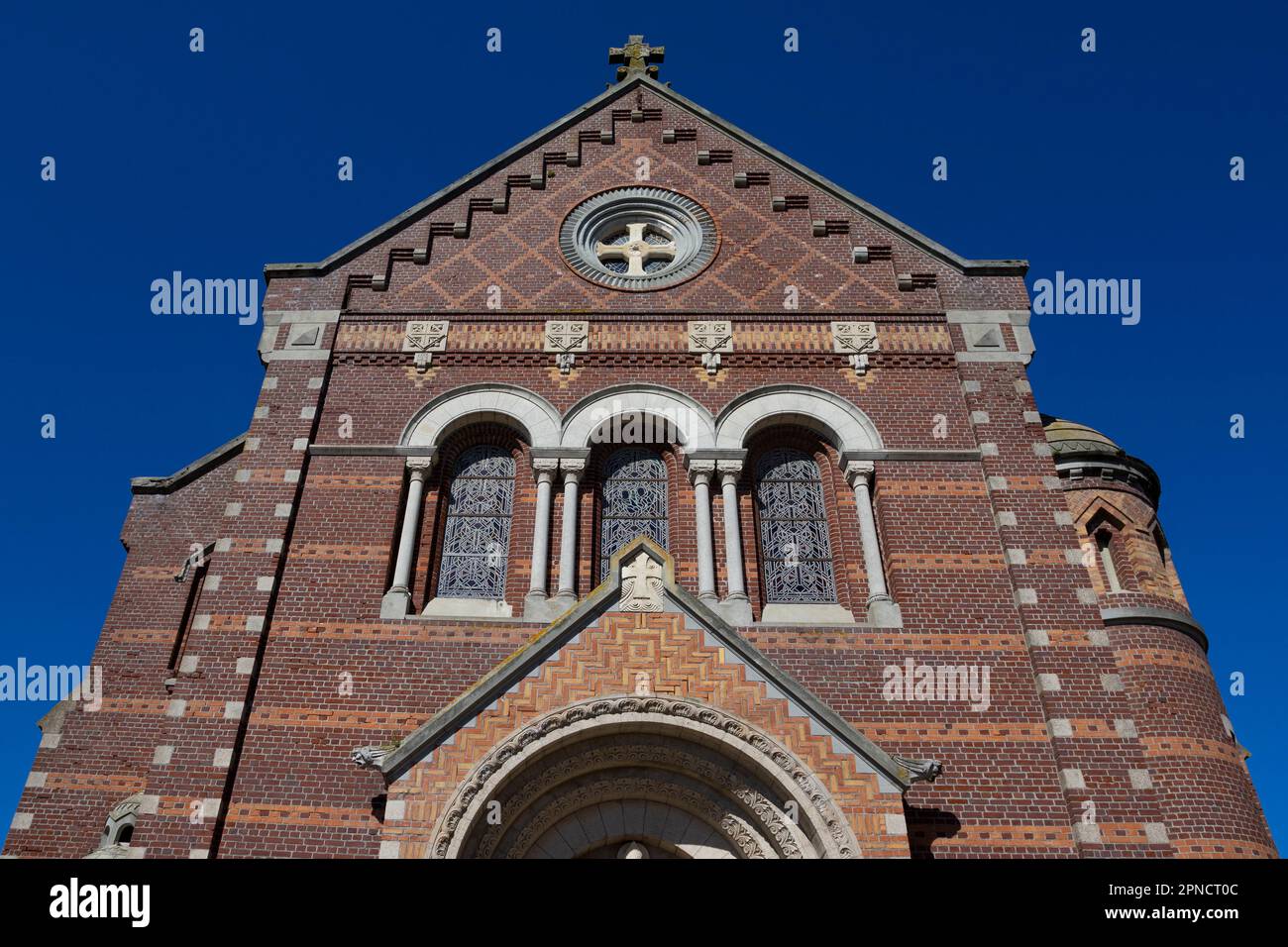 Außenfassade der romanisch-byzantinischen Kirche Saint Martin in Mers-les-bains im Departement Somme in Nordfrankreich. Sonnenlicht mit blauem Himmel. Stockfoto
