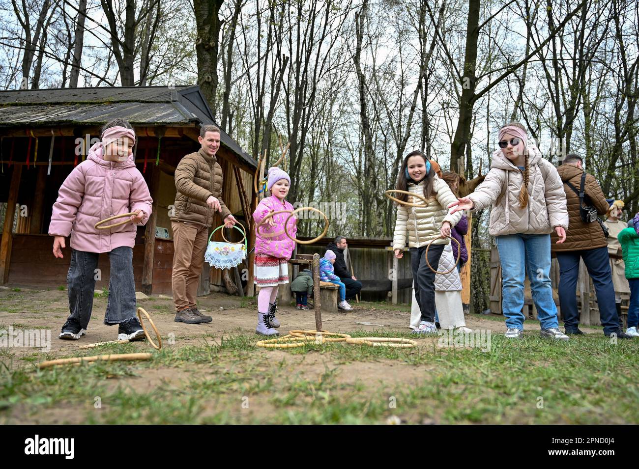 LEMBERG, UKRAINE - 16. APRIL 2023 - Erwachsene und Kinder werfen während der Osterfeier Ringe im Klymentii Sheptytskyi Museum für Volksarchitektur Stockfoto