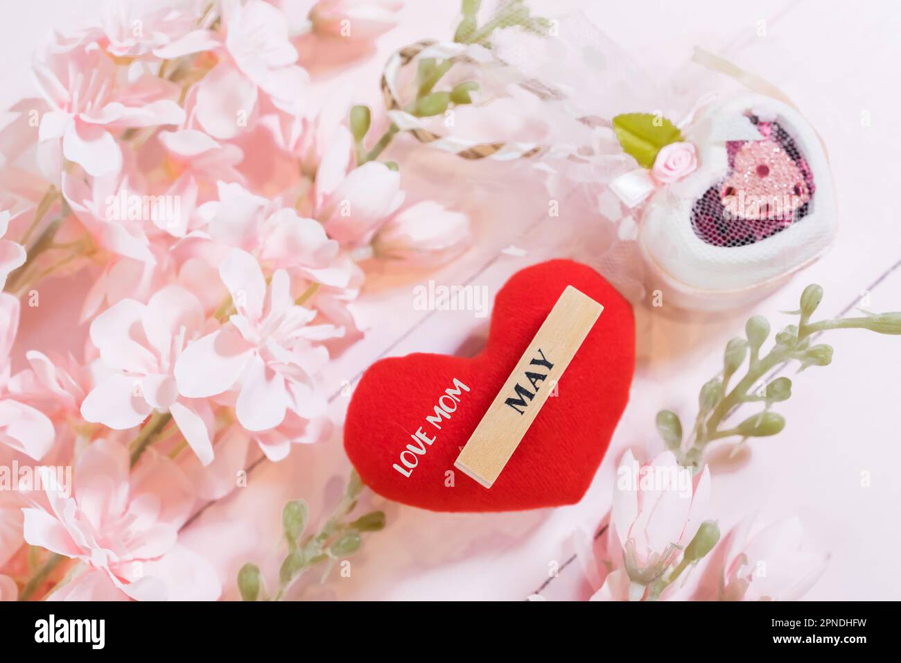 Jeden Tag ist Muttertag. Muttertagskonzepte und Sweetest Day, Love Concept. Rotes Herz mit dem Buchstaben LIEBE MOM mit wunderschöner Blume auf rosa Backg Stockfoto