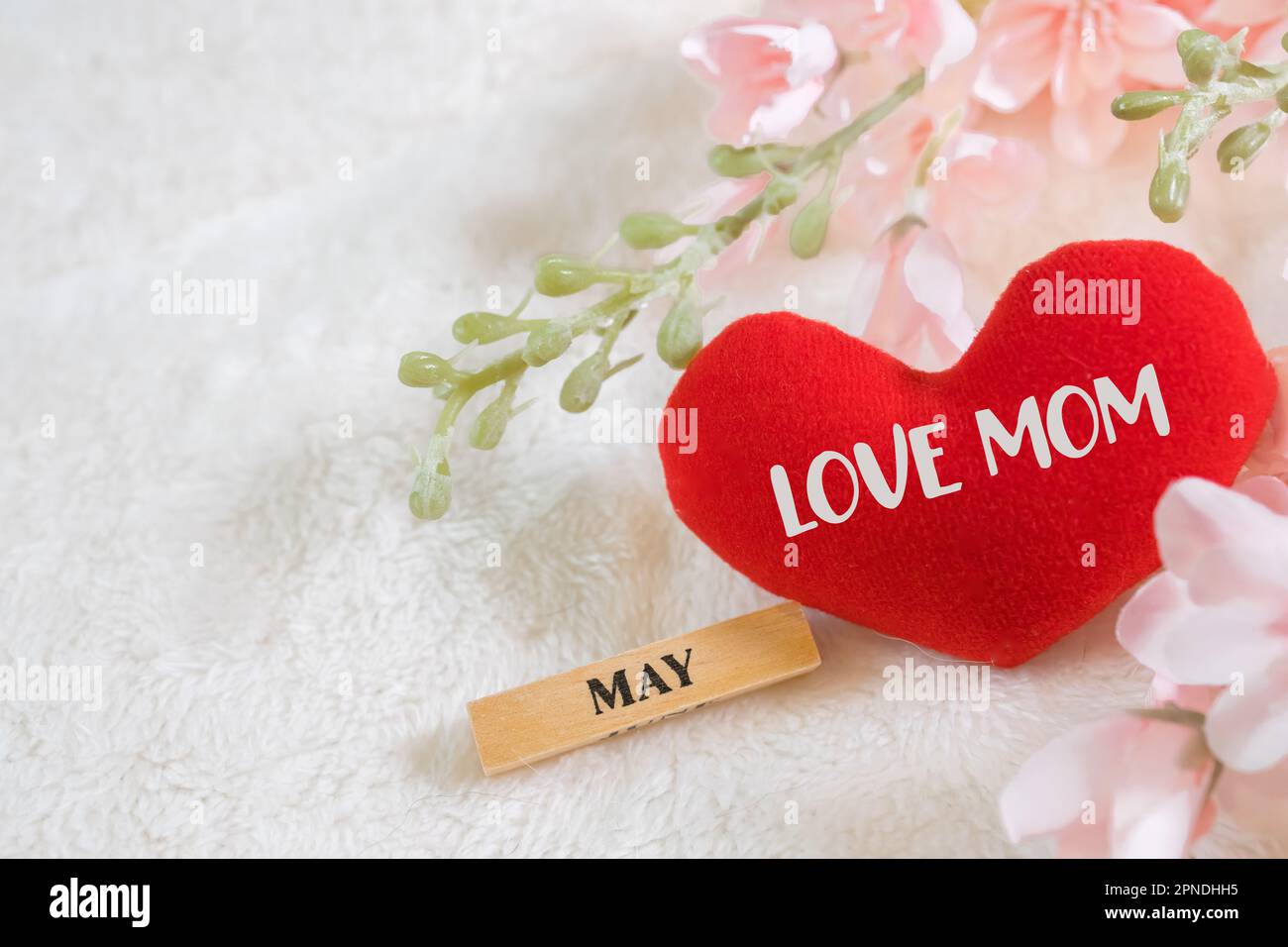 Jeden Tag ist Muttertag. Muttertagskonzepte und Sweetest Day, Love Concept. Rotes Herz mit dem Buchstaben LIEBE MOM mit wunderschöner Blume auf rosa Backg Stockfoto