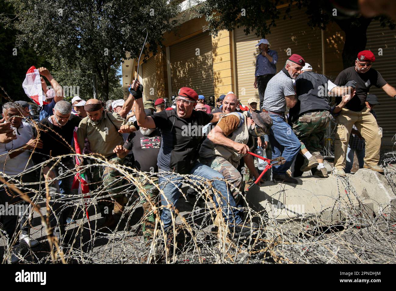 Beirut, Libanon. 18. April 2023. Pensionierte libanesische Soldaten kreuzen Stacheldraht als Versuch, die Grand Serail, das Hauptquartier der libanesischen Regierung in Beirut, zu stürmen. Als Folge der libanesischen Wirtschaftskrise und der rasanten Korruption gingen die pensionierten Militärs auf die Straßen der Innenstadt von Beirut, um gegen ihre finanziellen Schwierigkeiten zu protestieren. Kredit: Marwan Naamani/dpa/Alamy Live News Stockfoto