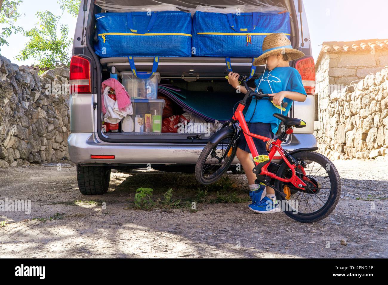 Ein Kind in einem Wohnmobil mit dem Fahrrad und dem Gepäck Stockfoto