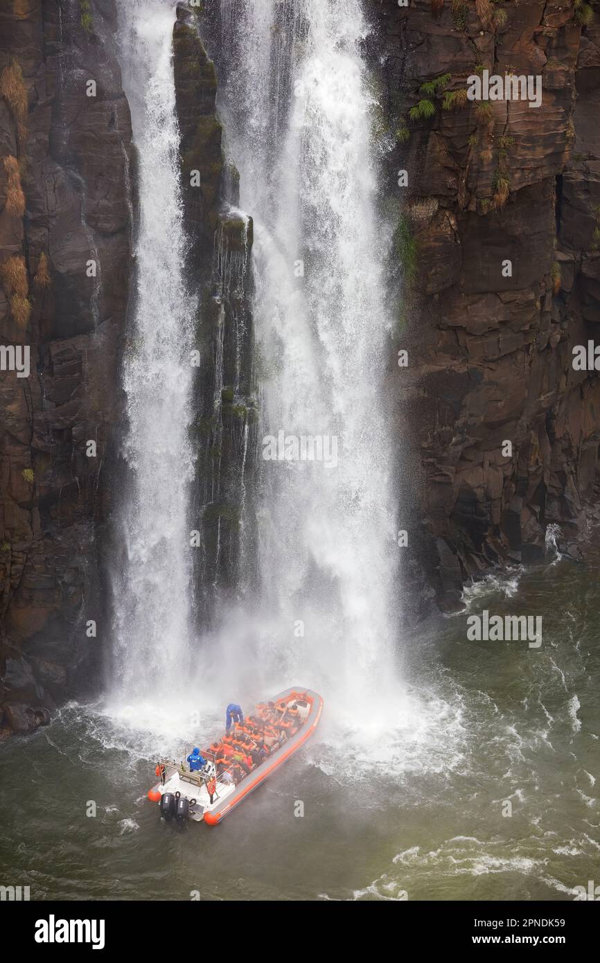 Ein Touristenboot nähert sich einem Wasserfall im Iguazú-Nationalpark, Brasilien. Stockfoto