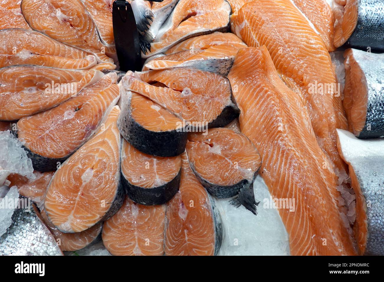 Viele frische, gekühlte Lachssteaks liegen auf dem Eis und werden im Sea Food Store aus nächster Nähe präsentiert Stockfoto