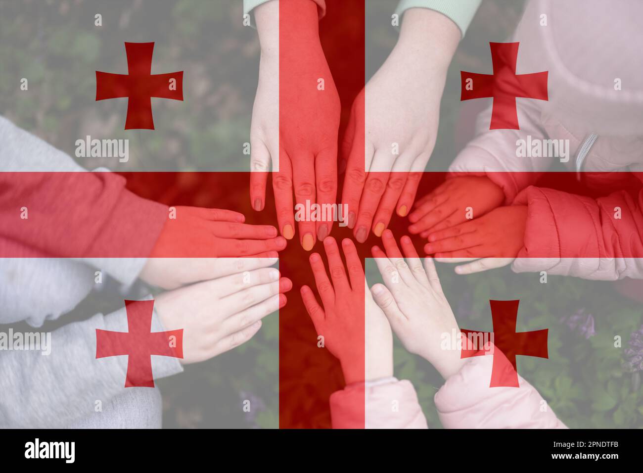 Hände von Kindern auf dem Hintergrund der Georgia-Flagge. Georgischer Patriotismus und Einheitskonzept. Stockfoto