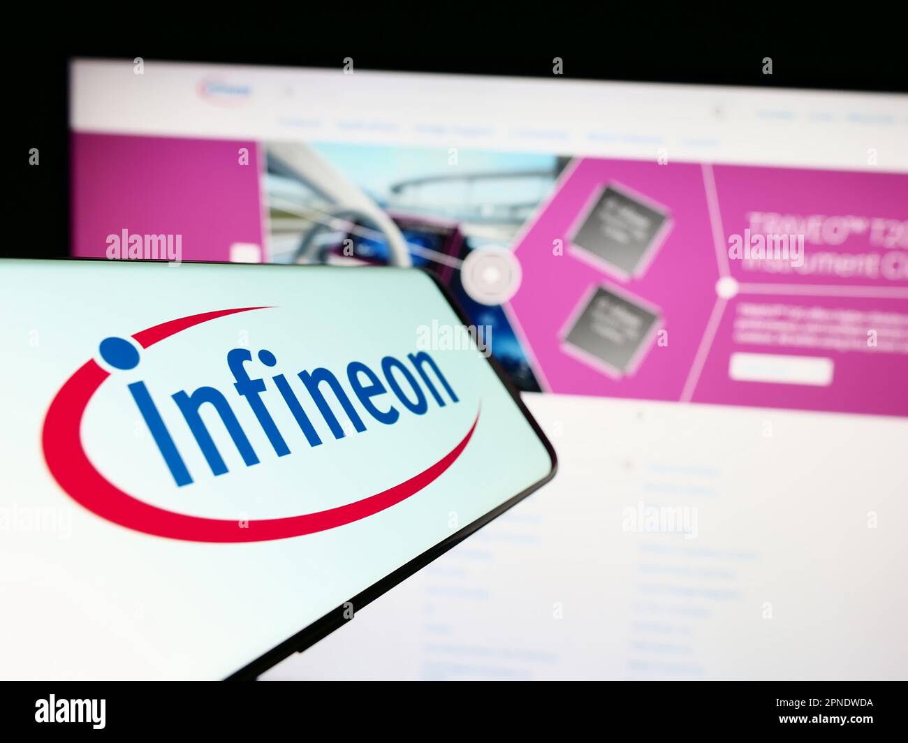 Mobiltelefon mit Logo des Halbleiterunternehmens Infineon Technologies AG auf dem Bildschirm vor der Website. Fokus auf die Mitte rechts des Telefondisplays. Stockfoto