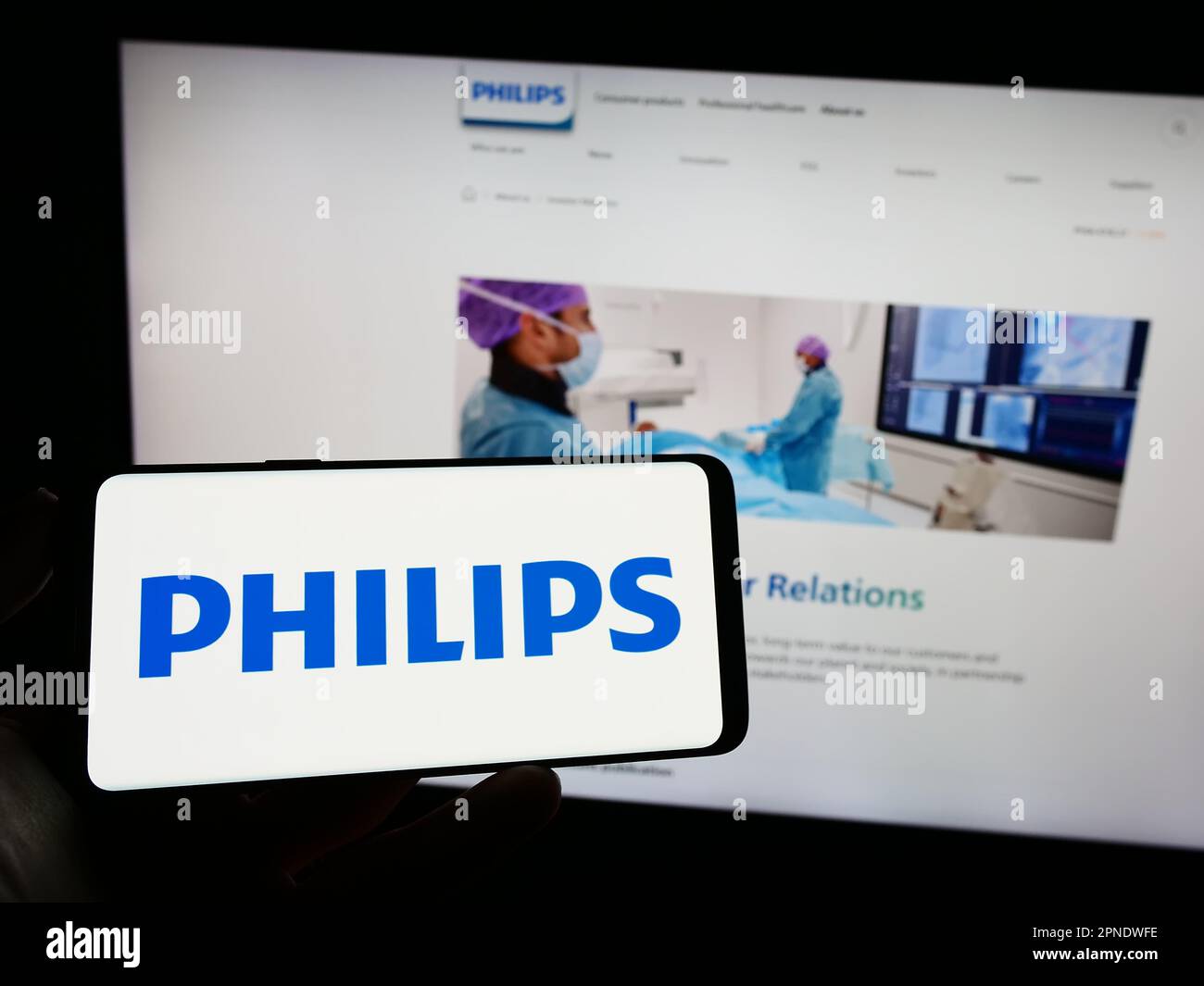 Person, die ein Mobiltelefon mit dem Logo des niederländischen Unternehmens Koninklijke Philips N.V. auf dem Bildschirm vor der geschäftlichen Webseite hält. Konzentrieren Sie sich auf das Display des Telefons. Stockfoto