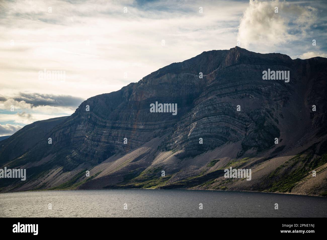 Sedimentschichten, sichtbar an der Seite der Berge entlang des Ufers von Saglek Fjord im Norden von Labrador, Kanada. Stockfoto