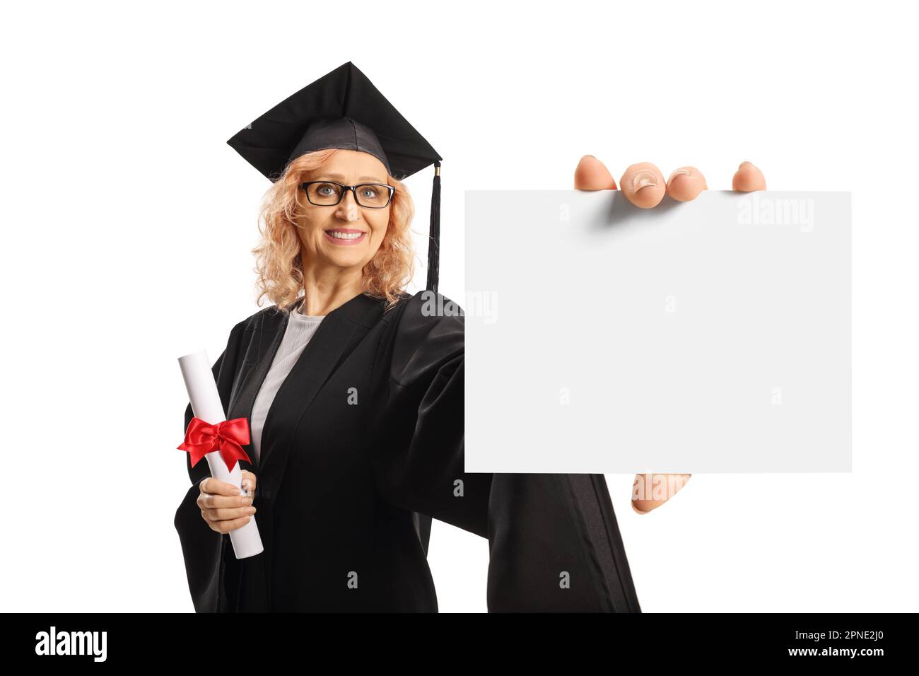 Reife Frau in einem Abschlusskleid mit einem Diplom und einer unbeschrifteten Karte isoliert auf weißem Hintergrund Stockfoto