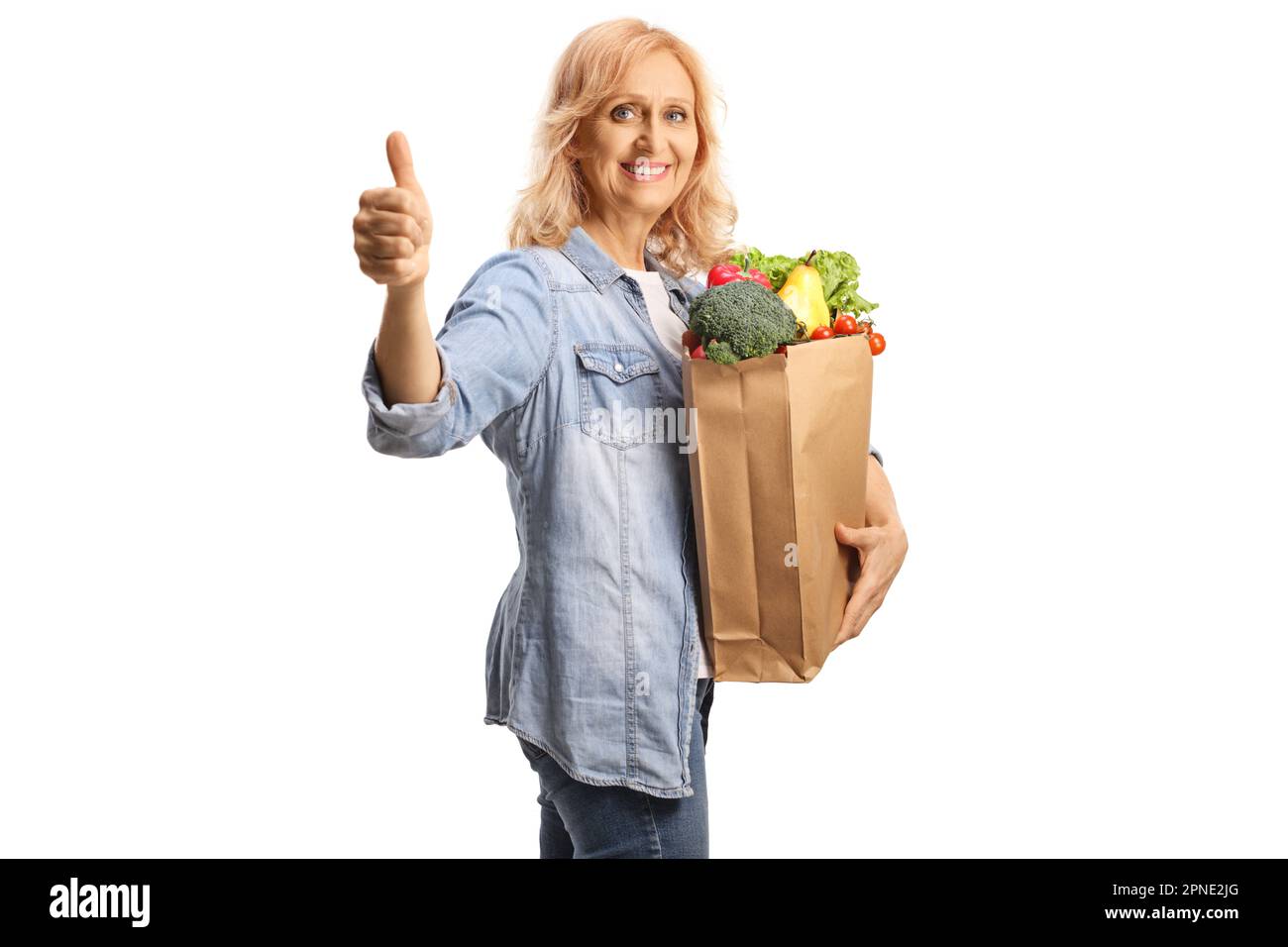 Eine Frau mit einer Einkaufstasche, die lächelt und die Daumen nach oben zeigt, isoliert auf weißem Hintergrund Stockfoto