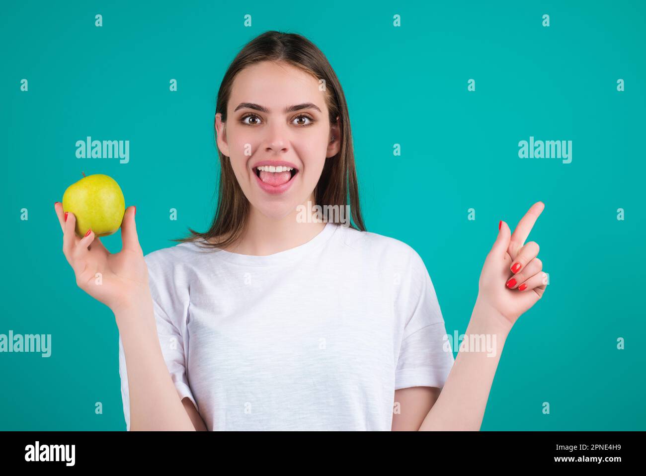 Das beißende Apfelkonzept. Porträt einer jungen Frau, die Apfel isst, isoliert im Studiohintergrund. Gesunde Apfelfrucht, natürliches Vitamin, Diät und vegan Stockfoto