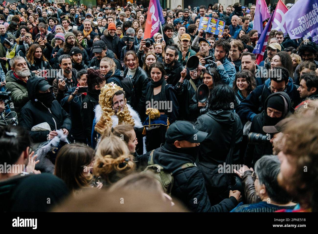 Jan Schmidt-Whitley/Le Pictorium - 17/4/2023 - Frankreich / Paris / Paris - UN manifestant grime en Macron/Louis XVI Traverse la foule sous les huees. Plusieurs milliers de personnes se sont reunies devant la mairie du 10e Arrondissement de Paris pour protester contre la Politique de Emmanuel Macron et contre la reforme des retraites. Plusieurs centaines de personnes ont ensuite parcouru Paris Pendant plusieurs heures en formant de multiples corteges sauvages et jouant au Chat et a la souris avec les Forces de l'ordre depassees par les evenements et la mobilite des groupes compose majoritaire Stockfoto