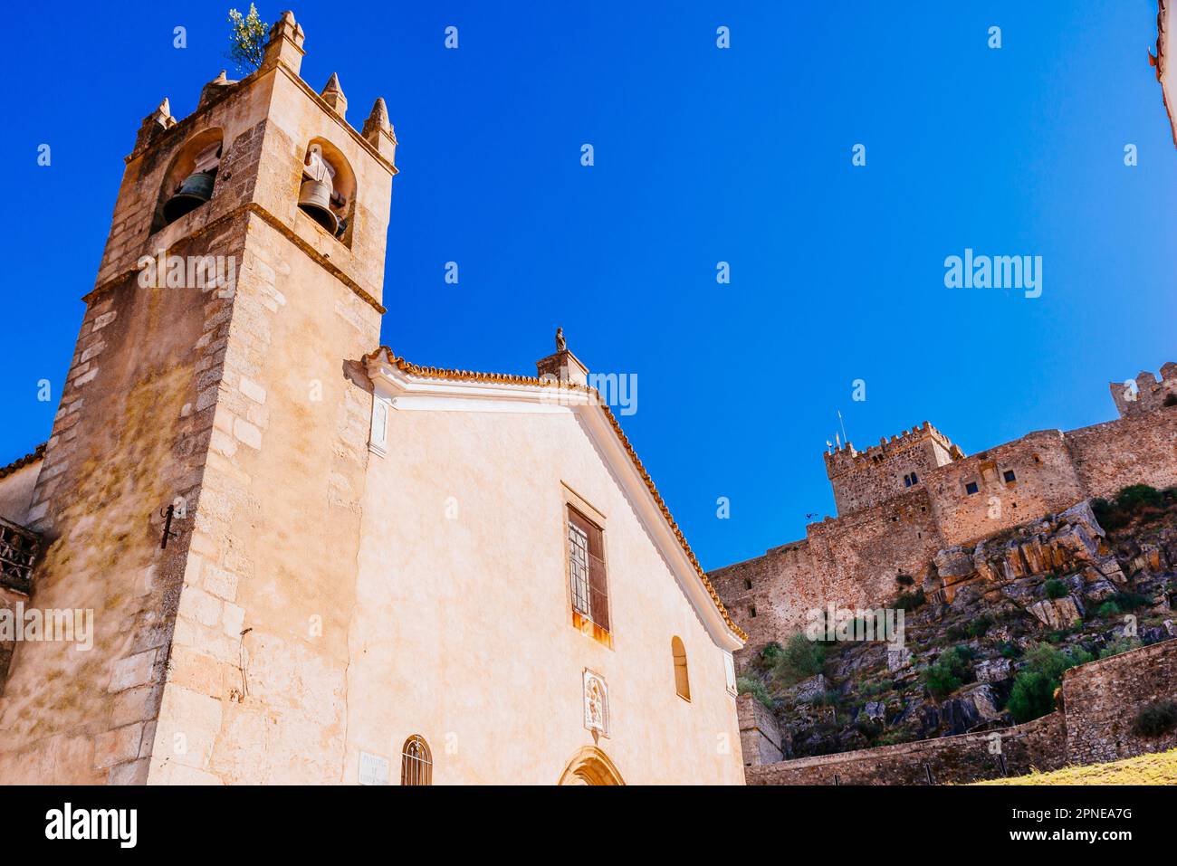 Die Kirche Santa María del Mercado ist ein katholischer Tempel aus dem 15. Jahrhundert. Im Hintergrund das Schloss von Luna. Alburquerque, Badajoz, Extremadura, Spanien, Stockfoto