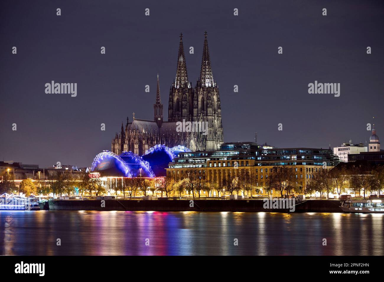 Stadtpanorama mit nur schwach beleuchtetem Kölner Dom, Musical Dome und Rhein bei Nacht, Deutschland, Nordrhein-Westfalen, Köln Stockfoto