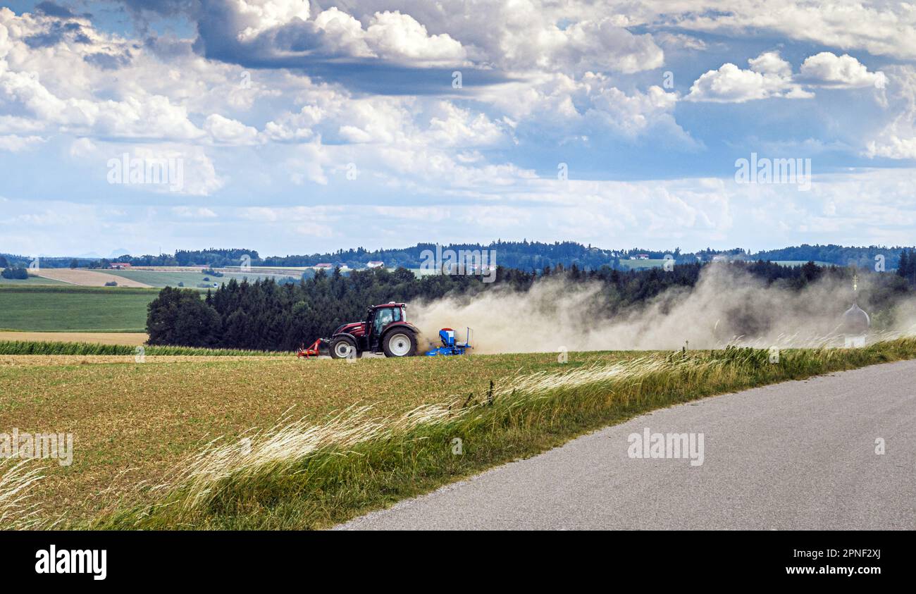 Landwirt mit Traktor auf staubtrockenem Feld, Deutschland, Bayern, Isental Stockfoto