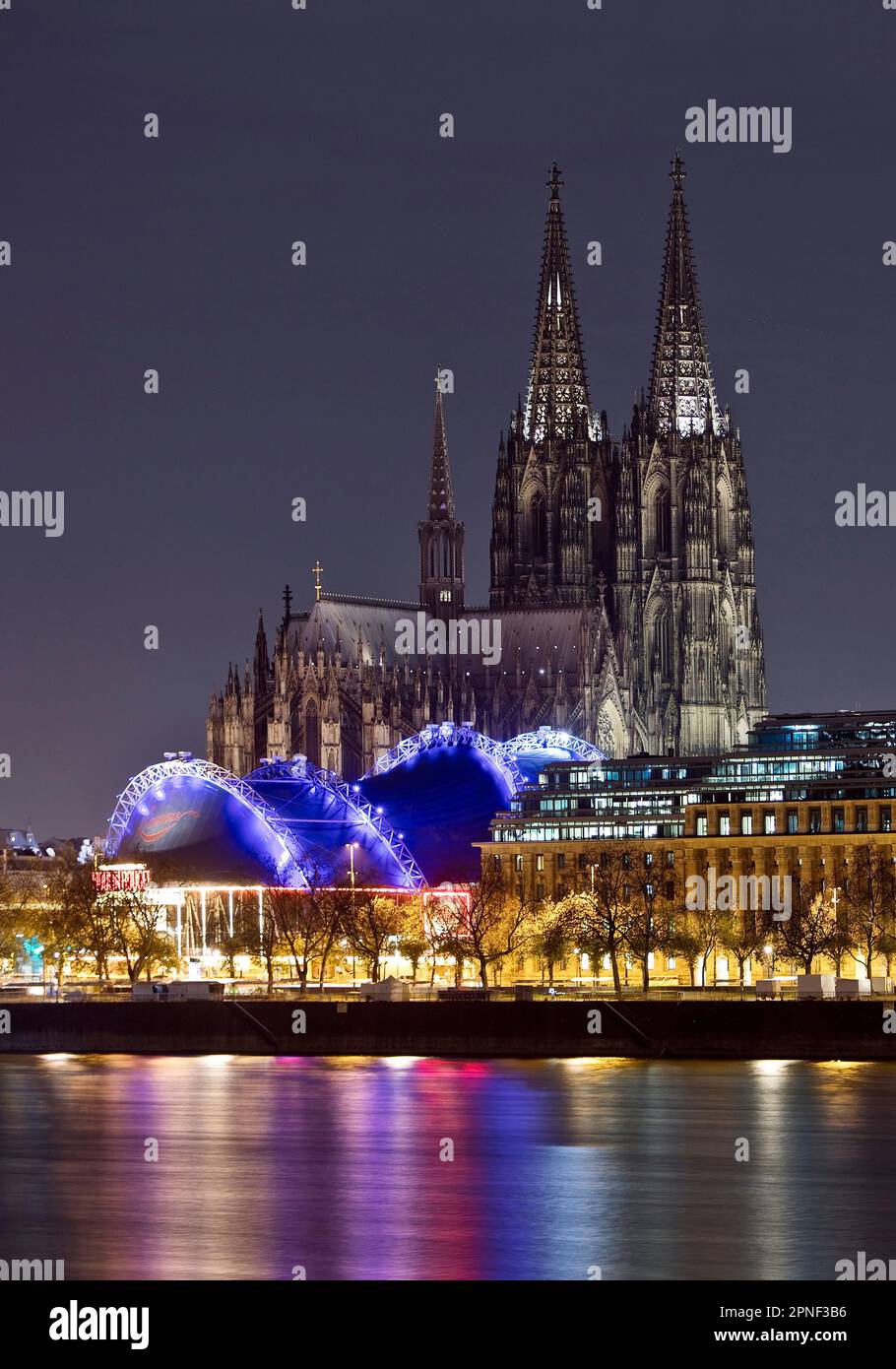 Stadtpanorama mit nur schwach beleuchtetem Kölner Dom, Musical Dome und Rhein bei Nacht, Deutschland, Nordrhein-Westfalen, Köln Stockfoto