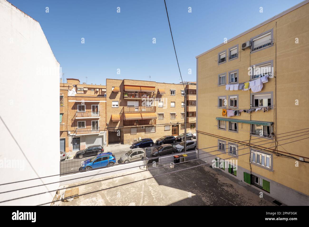 Ein leeres Grundstück zwischen Gebäuden in einer engen Straße in einem Madrider Viertel an einem sonnigen Sommertag Stockfoto