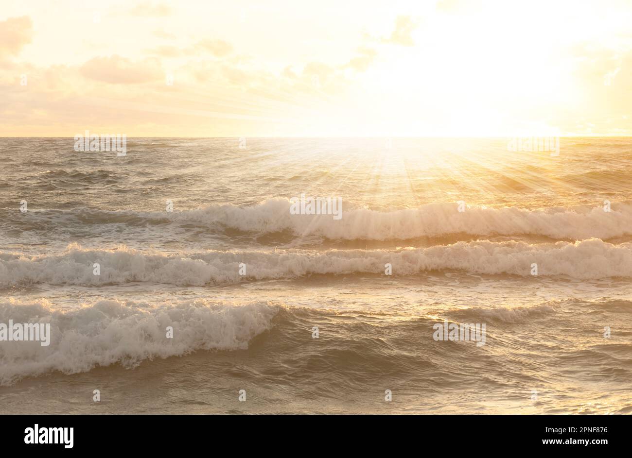 Die untergehende Sonne scheint über dem Meer Stockfoto