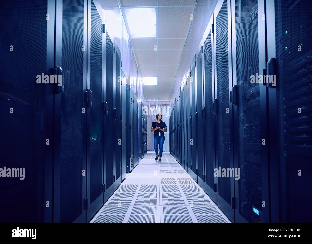 Eine Technikerin, die in den Serverraum kommt Stockfoto