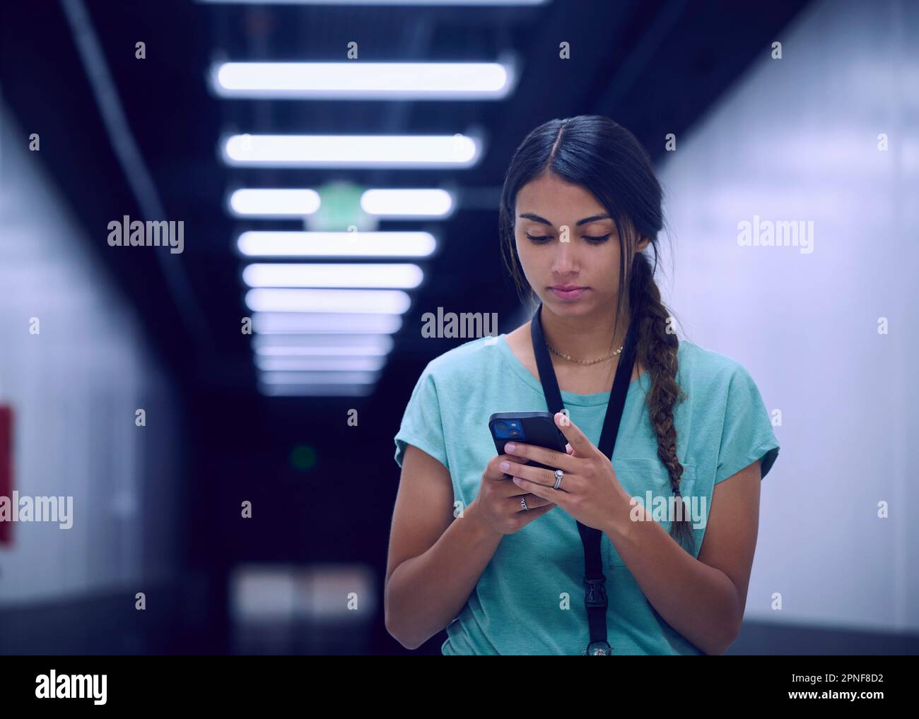 Eine Technikerin, die auf ein Smartphone schaut Stockfoto