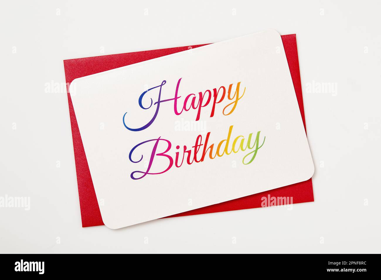 Bunte Geburtstagskarte „Happy Birthday“ auf rotem Umschlag Stockfoto