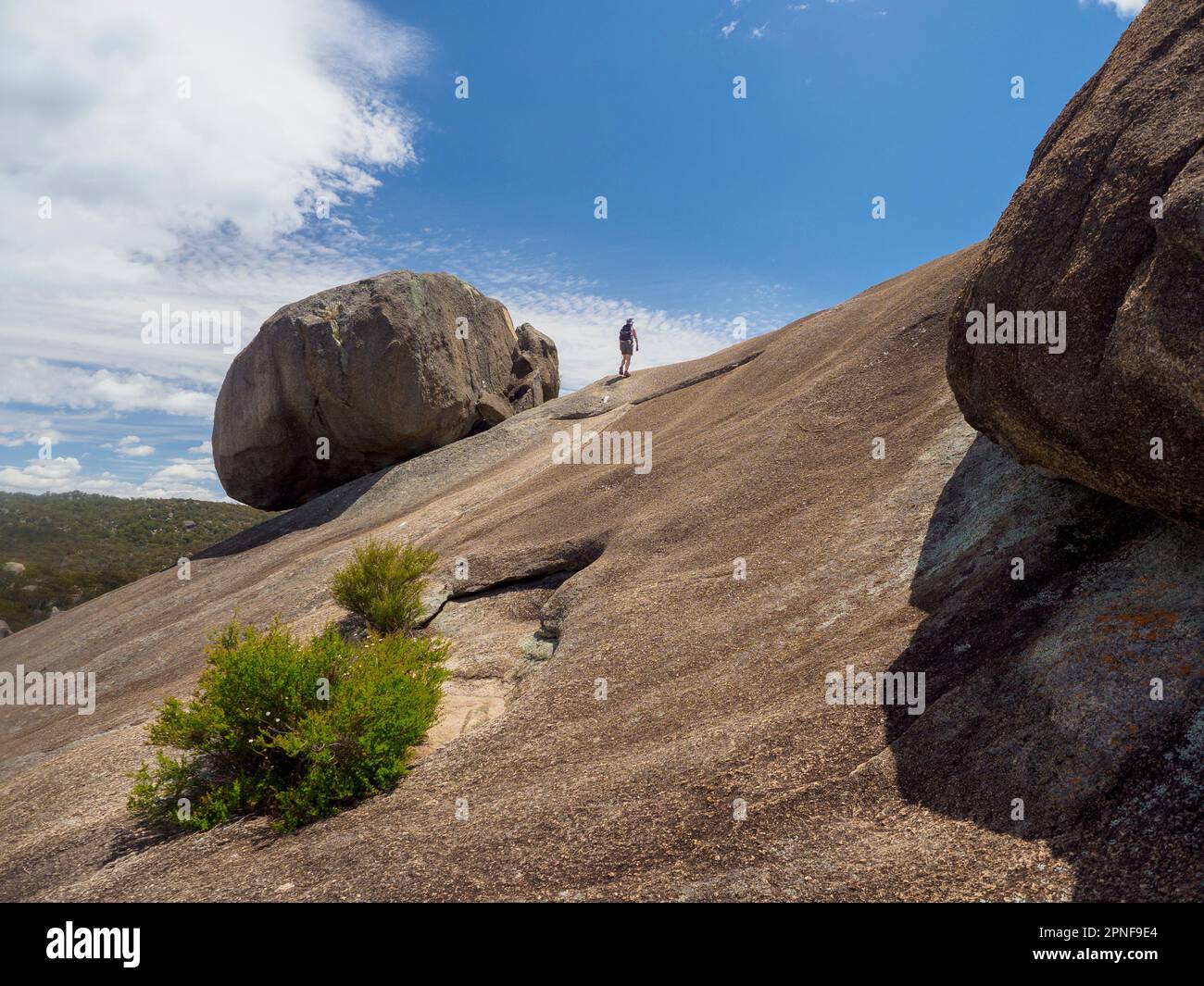 Australien, Queensland, Girraween-Nationalpark, Frau, die auf Felsformationen wandert Stockfoto