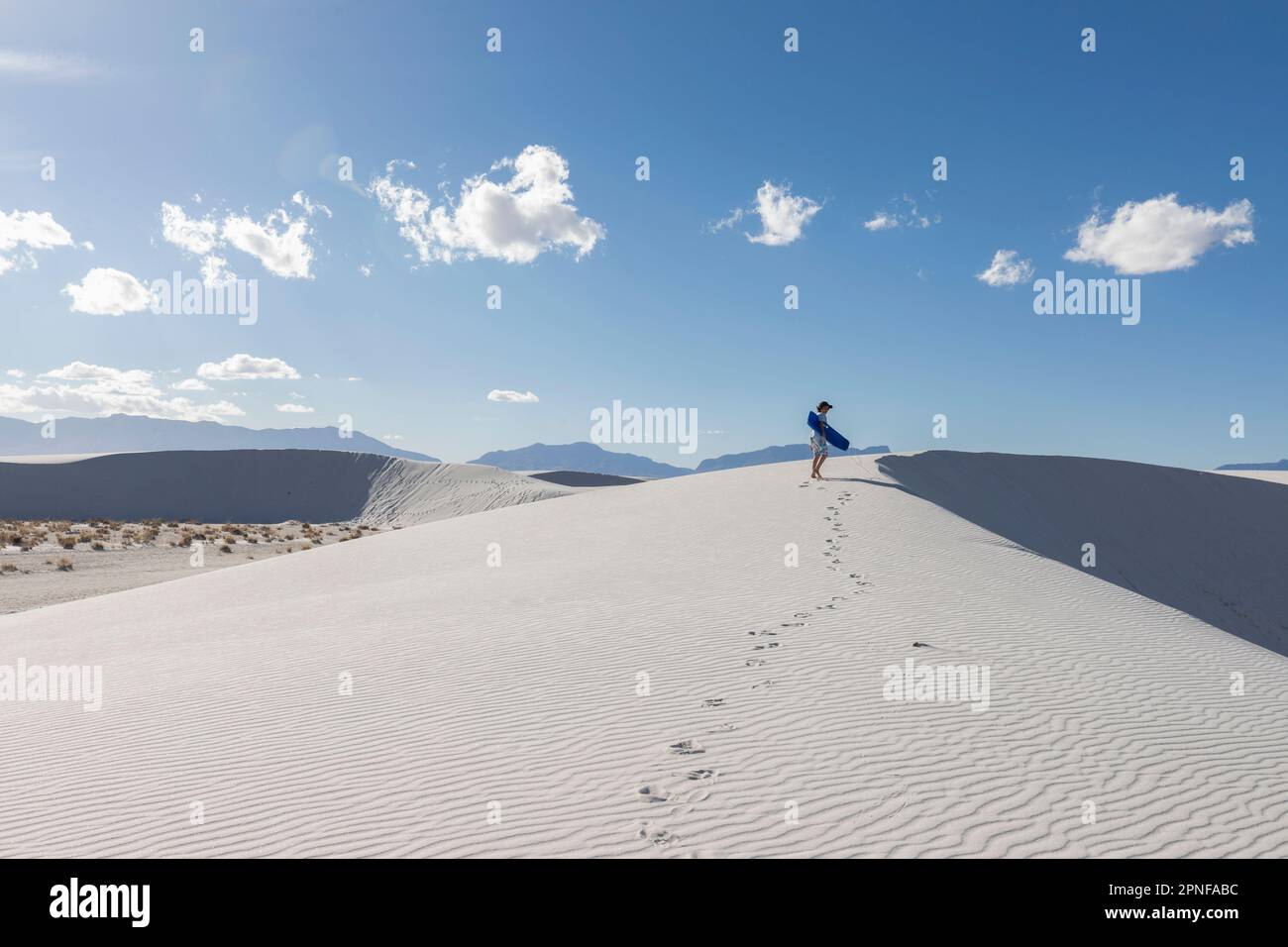 USA, New Mexico, White Sands National Park, Boy (10-11) mit Schlitten in der Wüste Stockfoto