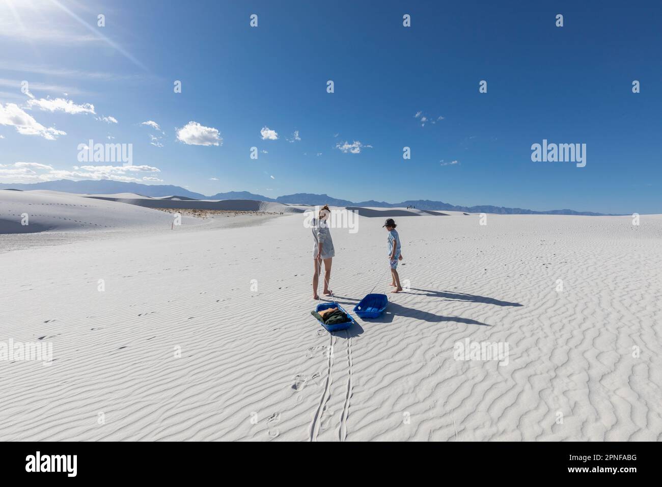 USA, New Mexico, White Sands Nationalpark, Bruder (10-11) und Schwester mit Schlitten in der Wüste Stockfoto