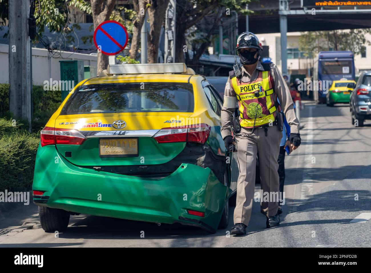 SAMUT PRAKAN, THAILAND, JANUAR 21 2023, Ein Polizist mit einem Taxifahrer in einem abgestürzten Taxi Stockfoto