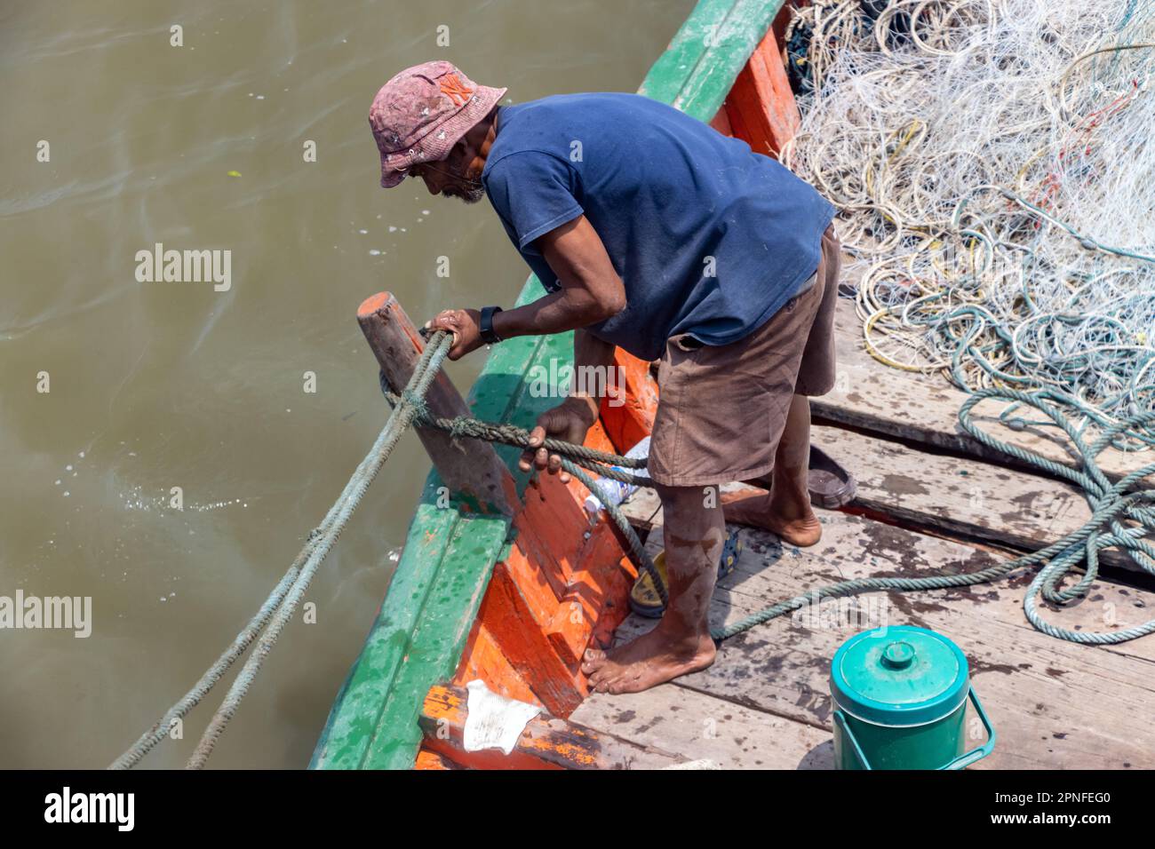 SAMUT PRAKAN, THAILAND, MÄRZ 14 2023, Ein Fischer arbeitet auf einem Fischerboot Stockfoto