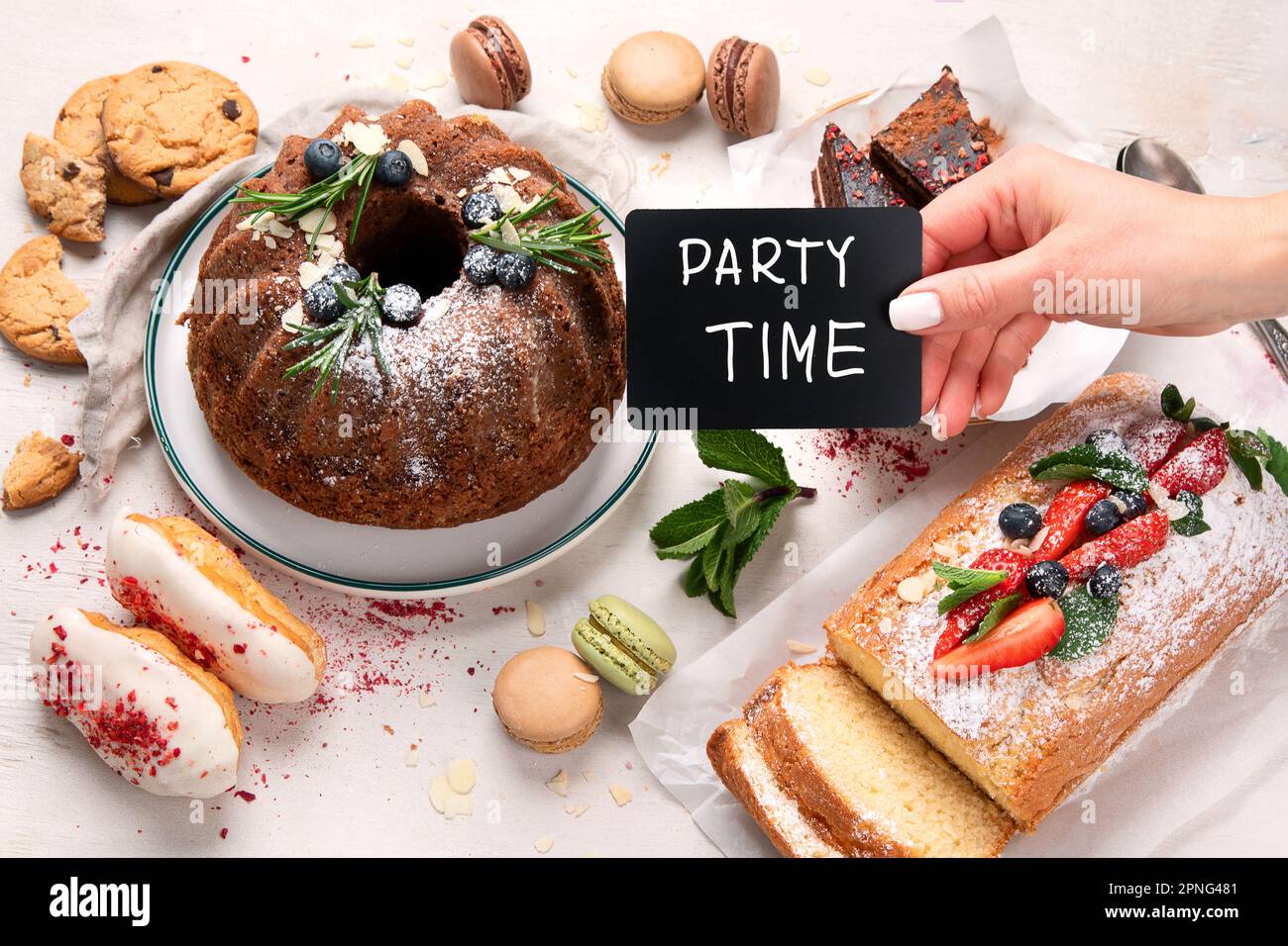 Desserttisch mit verschiedenen gebündelten Kuchen, Stückchen Kuchen, Süßigkeiten, Kekse mit Obstgarn auf weißem Hintergrund. Draufsicht. Stockfoto