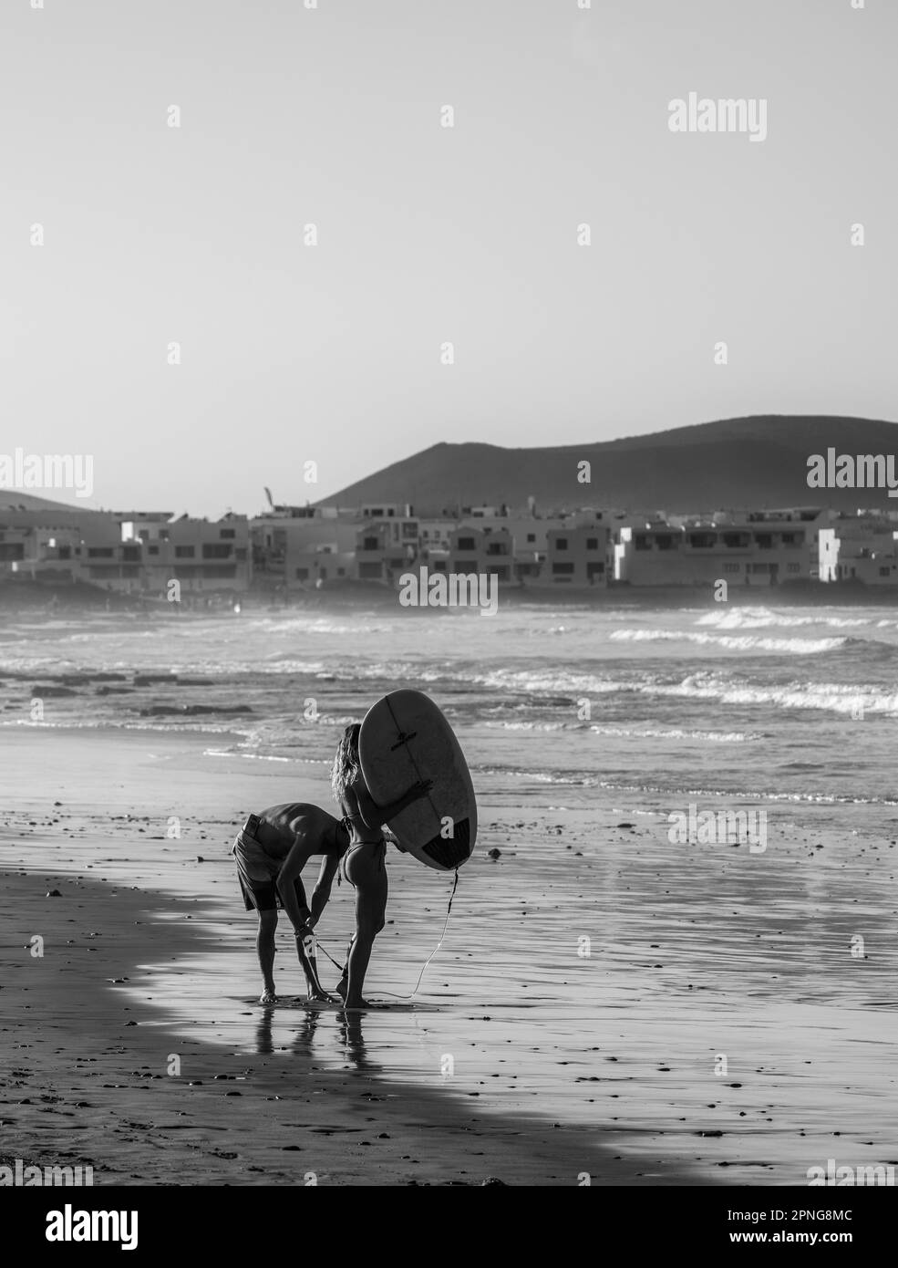 Schwarzweißfotografie, Surfer am Strand, Playa Famara, Lanzarote, Kanarische Inseln, Spanien Stockfoto