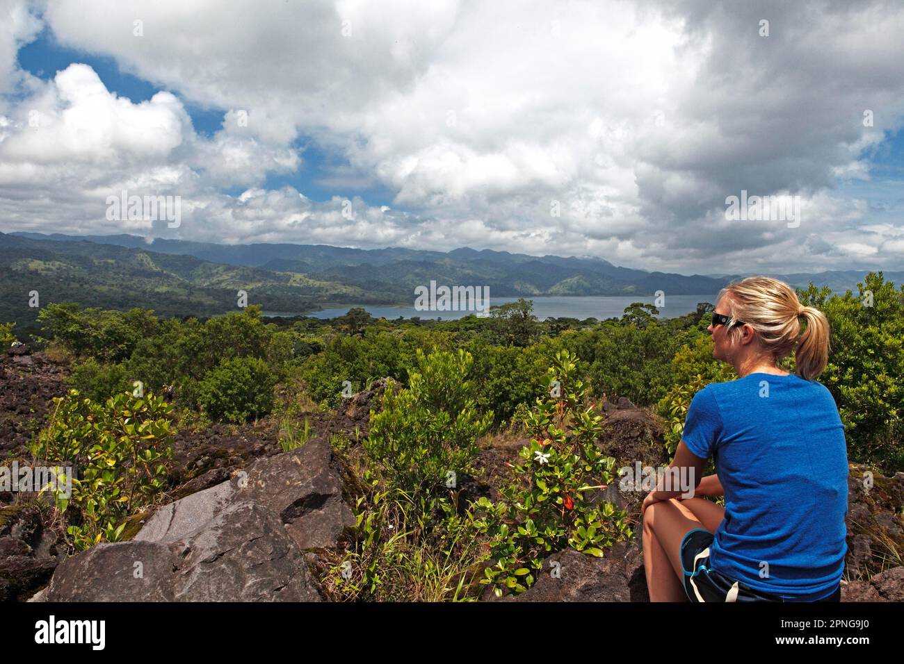 Eine Frau, die auf den Arenalsee, die Provinzen Guanacaste und Alajuela, Costa Rica schaut Stockfoto