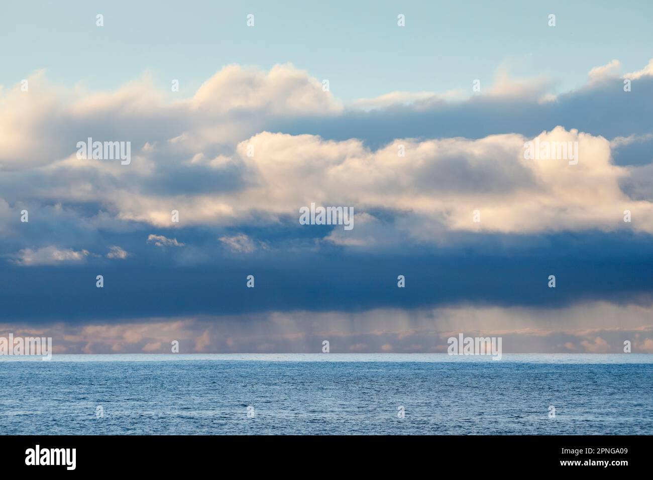 Tief liegende Regenwolken treiben über das offene Wasser des blauen Atlantischen Ozeans Stockfoto