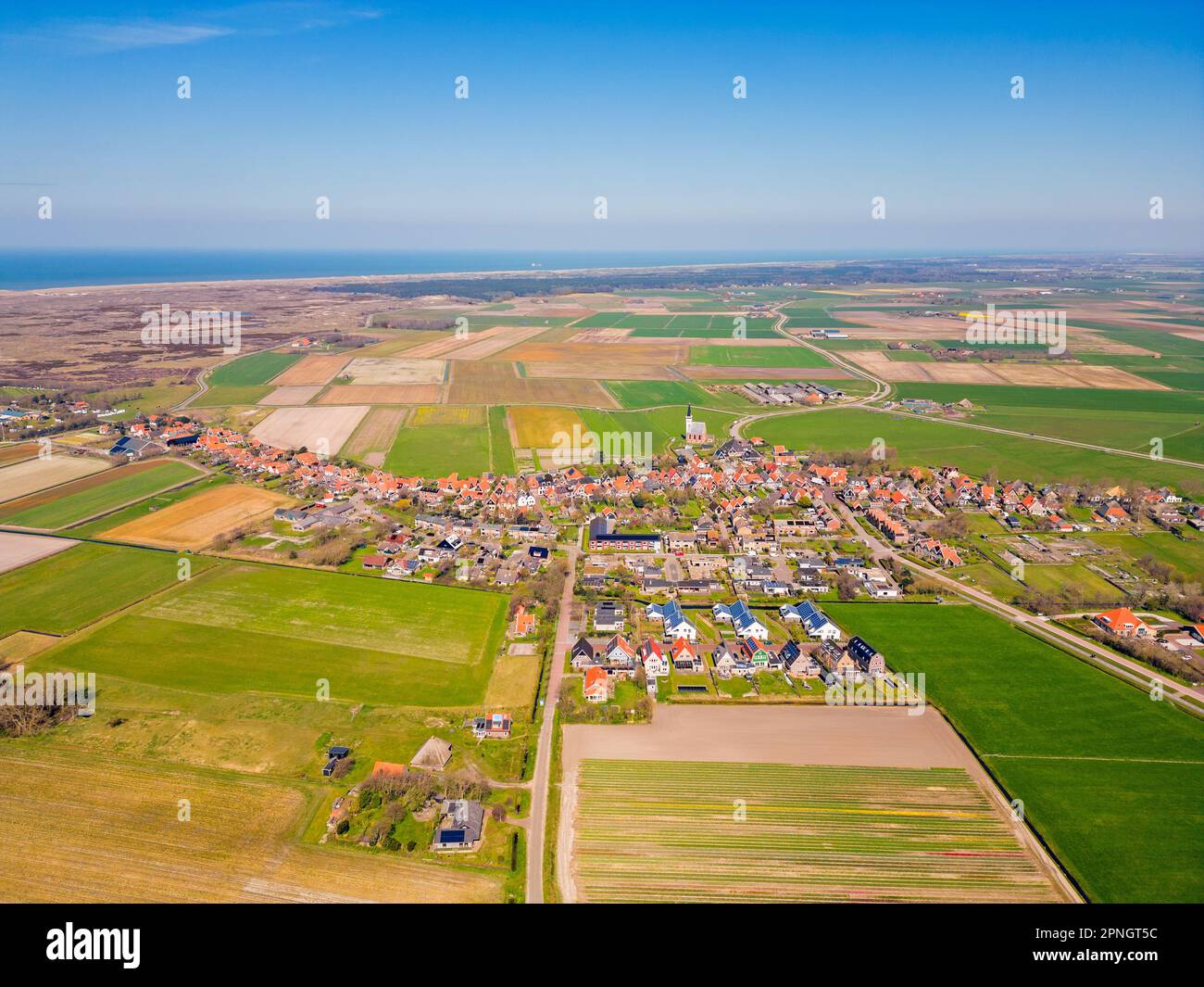 High Angle Drone Point of View im Dorf Den Hoorn auf der Insel Texel, Niederlande. Das Wattenmeer ist in der Ferne zu sehen. Stockfoto