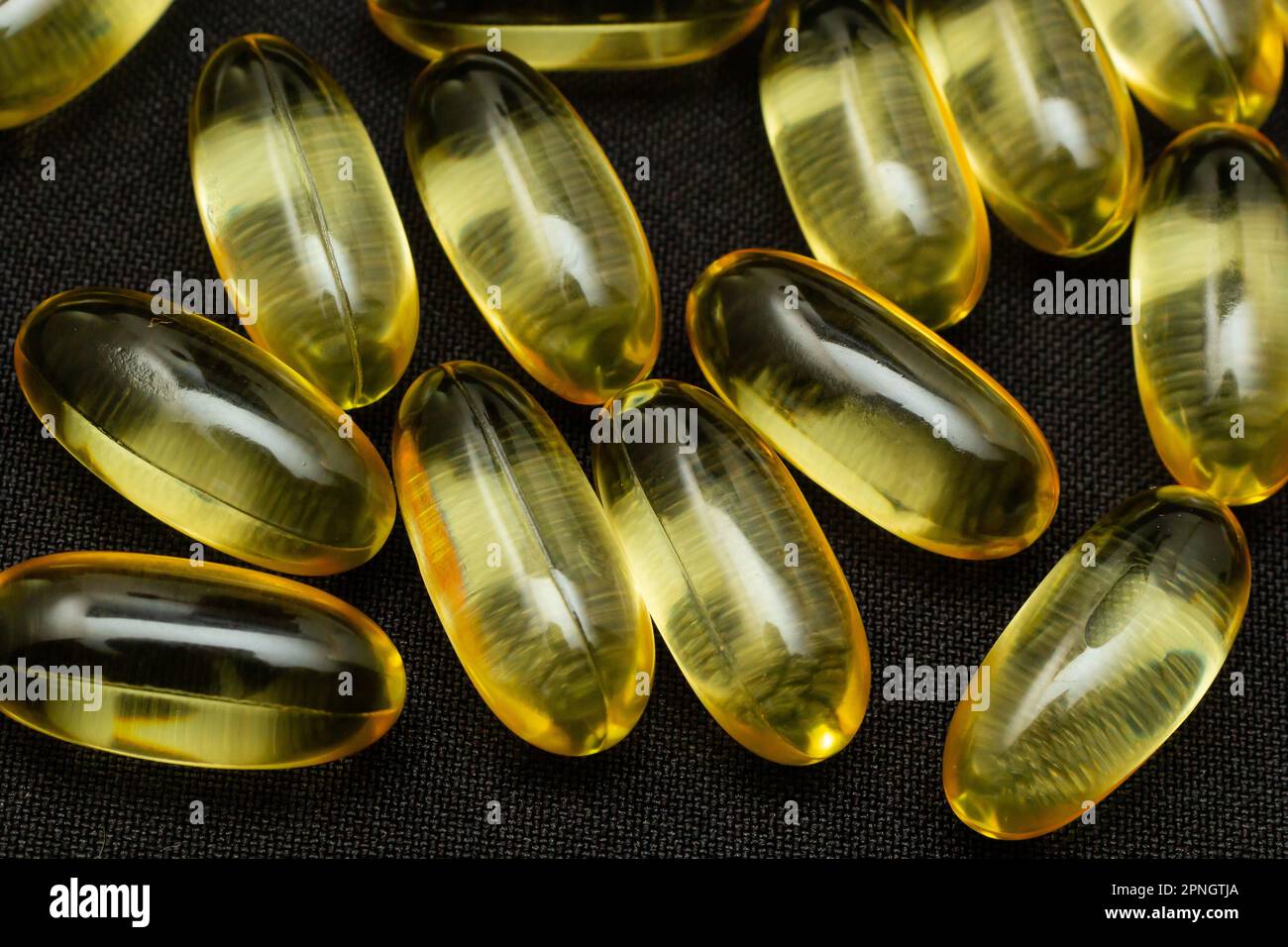 Makro-Nahaufnahme der Omega 3-Gelkapsel auf reflektierendem schwarzem Hintergrund. Stockfoto
