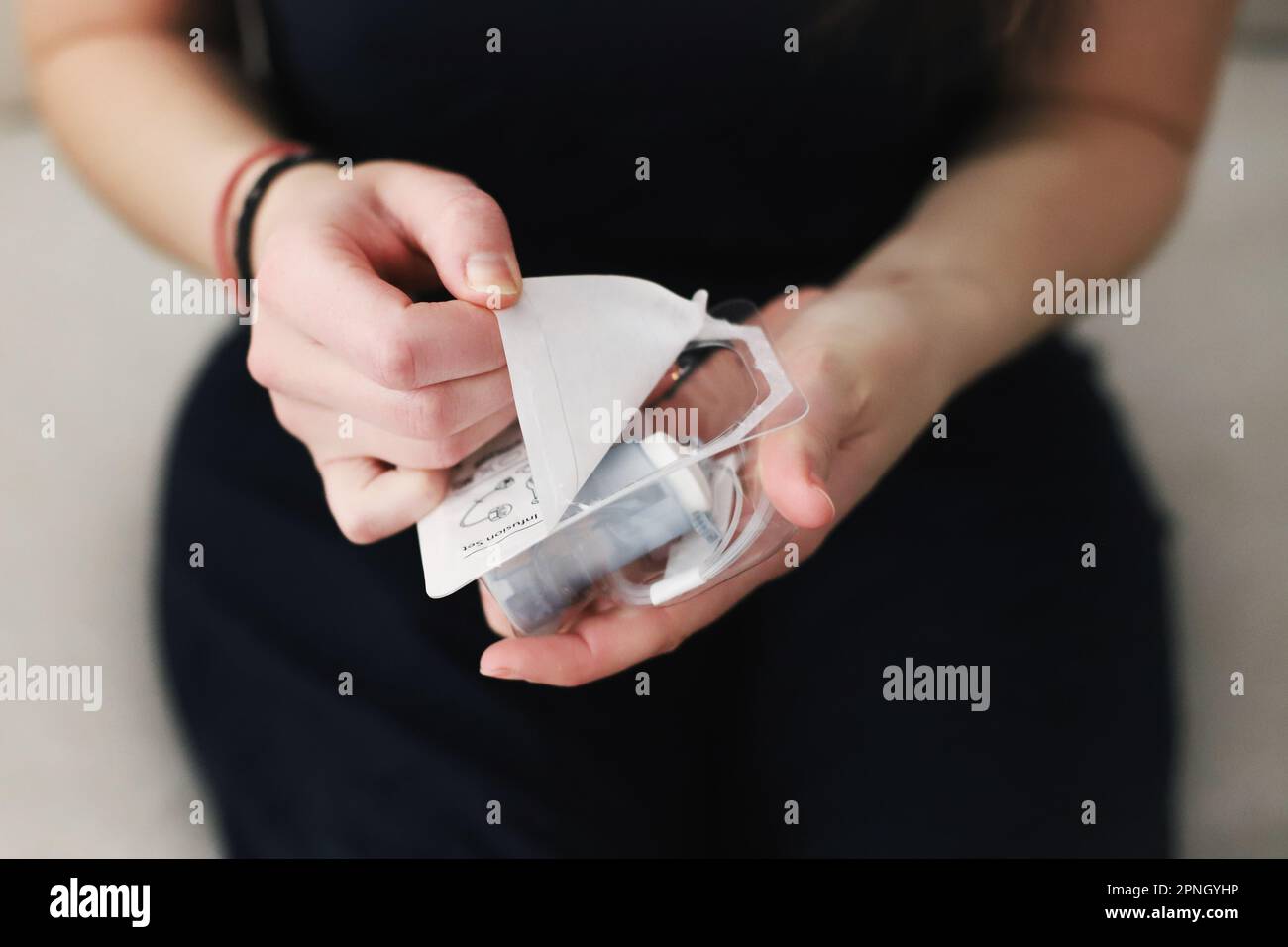 Weibliche Hände packen ein neues Infusionsset aus Stockfoto