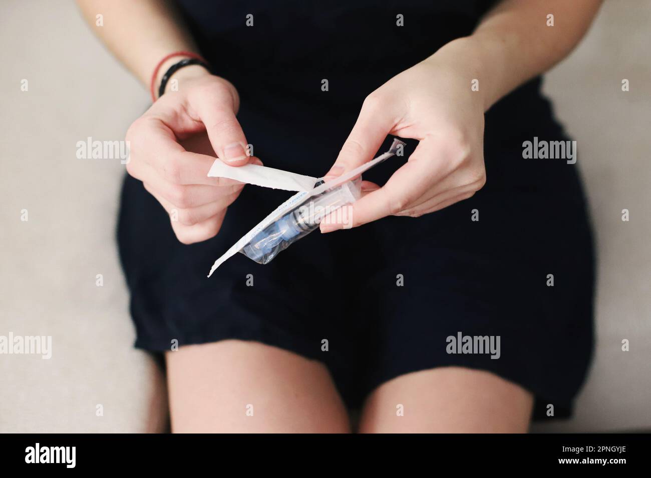 Weibliche Hände packen ein neues Reservoir für die Insulinpumpe aus Stockfoto