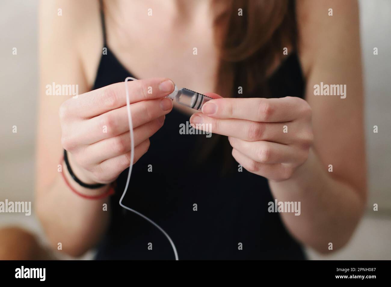 Eine Frau mit einem Reservoir, der gerade mit Insulin für ihre Insulinpumpe gefüllt ist Stockfoto
