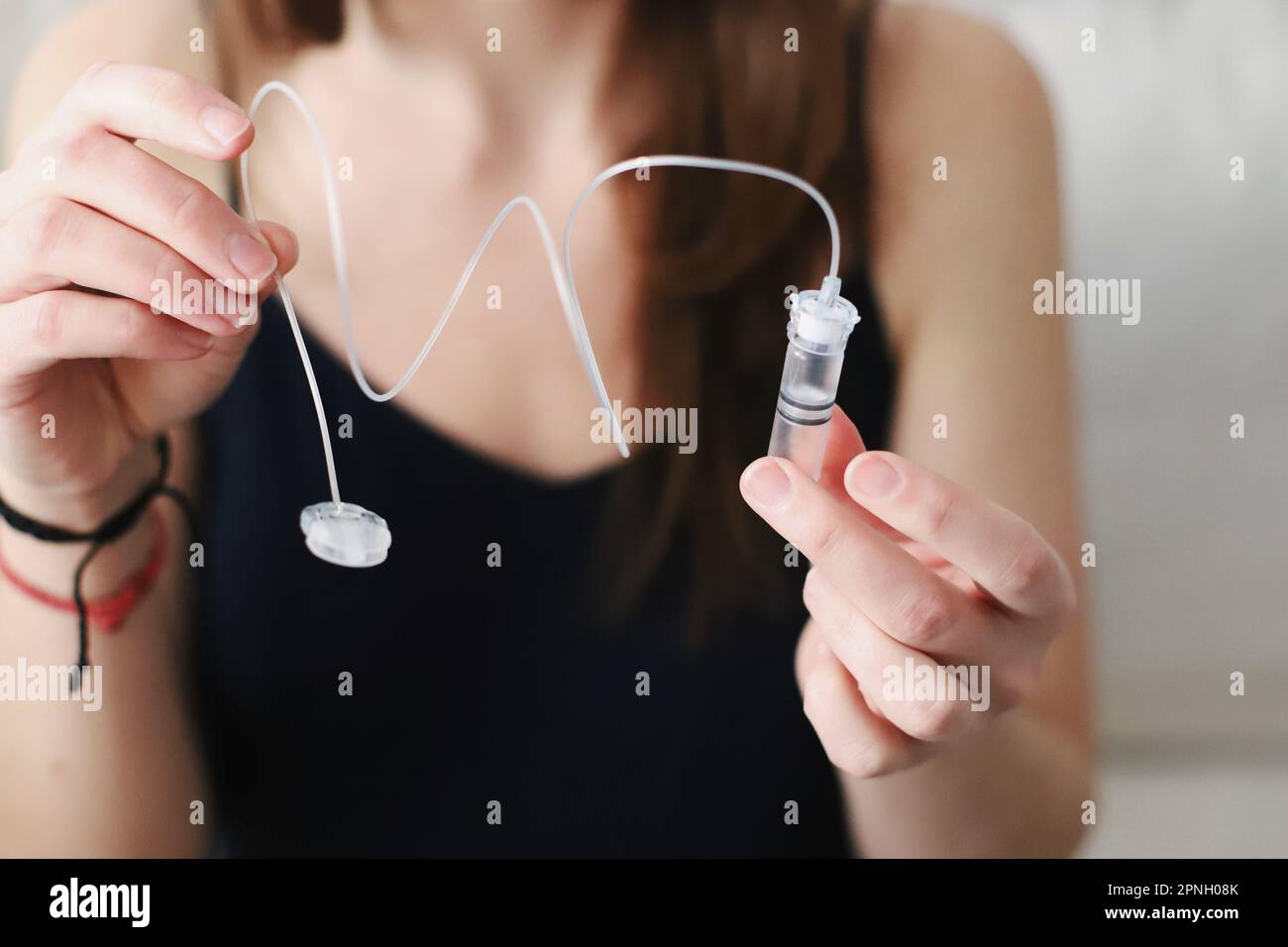 Eine Frau mit einem Reservoir, der gerade mit Insulin für ihre Insulinpumpe gefüllt ist Stockfoto