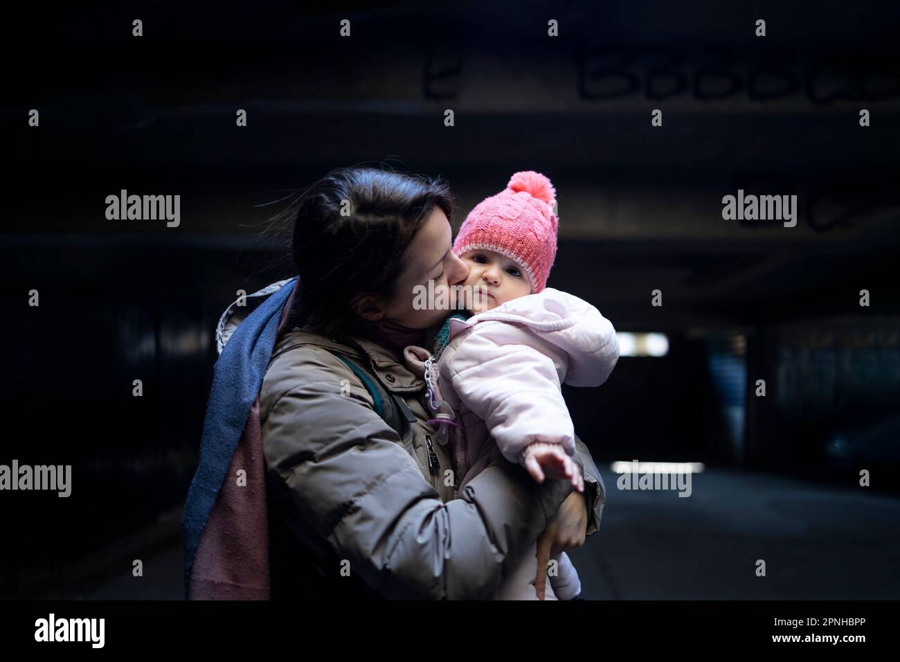 Eine Mutter, die ihr kleines Baby in einem Luftschutzbunker hält Stockfoto