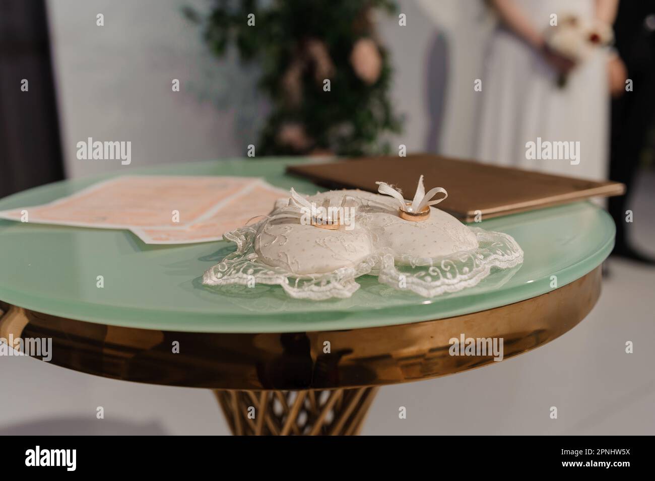 Ein Paar goldene Eheringe auf einem weißen Kissen Stockfoto